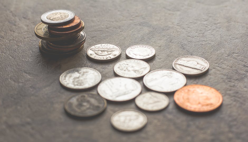 灰色の表面にさまざまなシルバーとゴールドの色のコイン