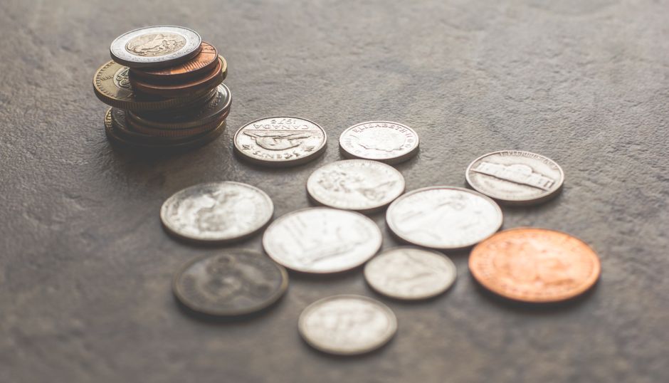 灰色の表面にさまざまなシルバーとゴールドの色のコイン