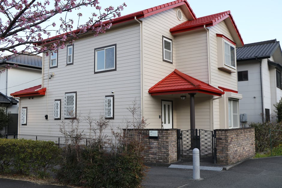 鮮やかな赤い屋根が、満開の桜に囲まれた、モダンな郊外住宅。