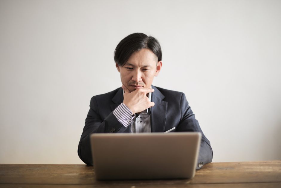 シルバーmacbookを使用して青いコートの男