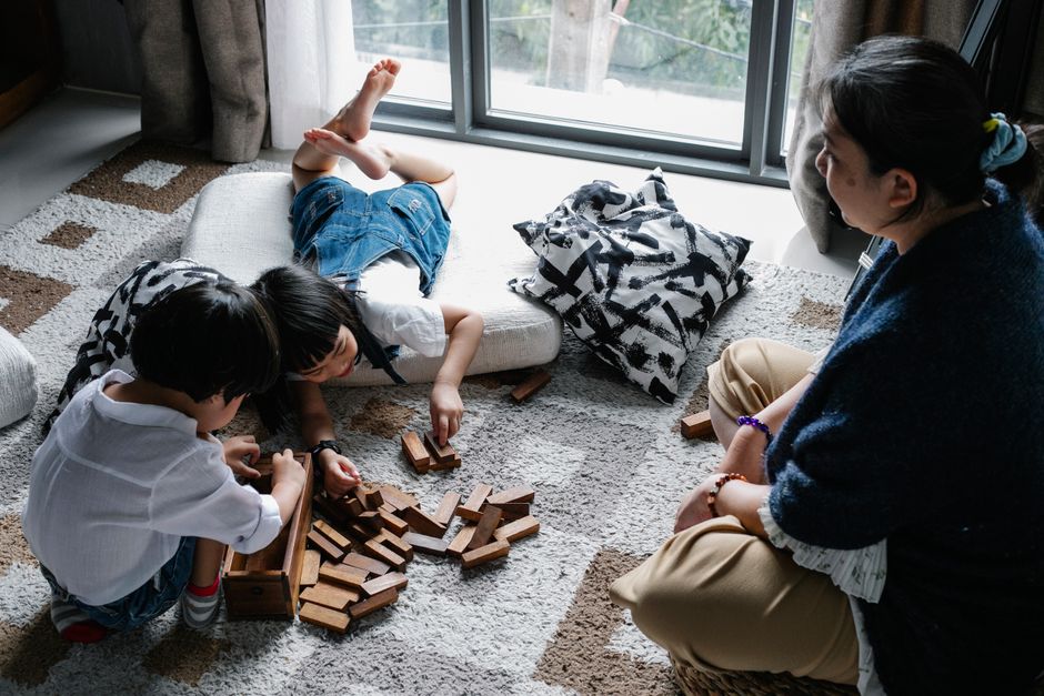 タワーゲームをしているアジアの子供たちを見ている祖母