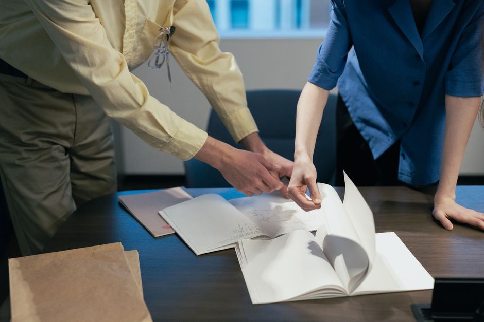 職場でのディスカッションに参加し、書類を確認している2人の専門家。